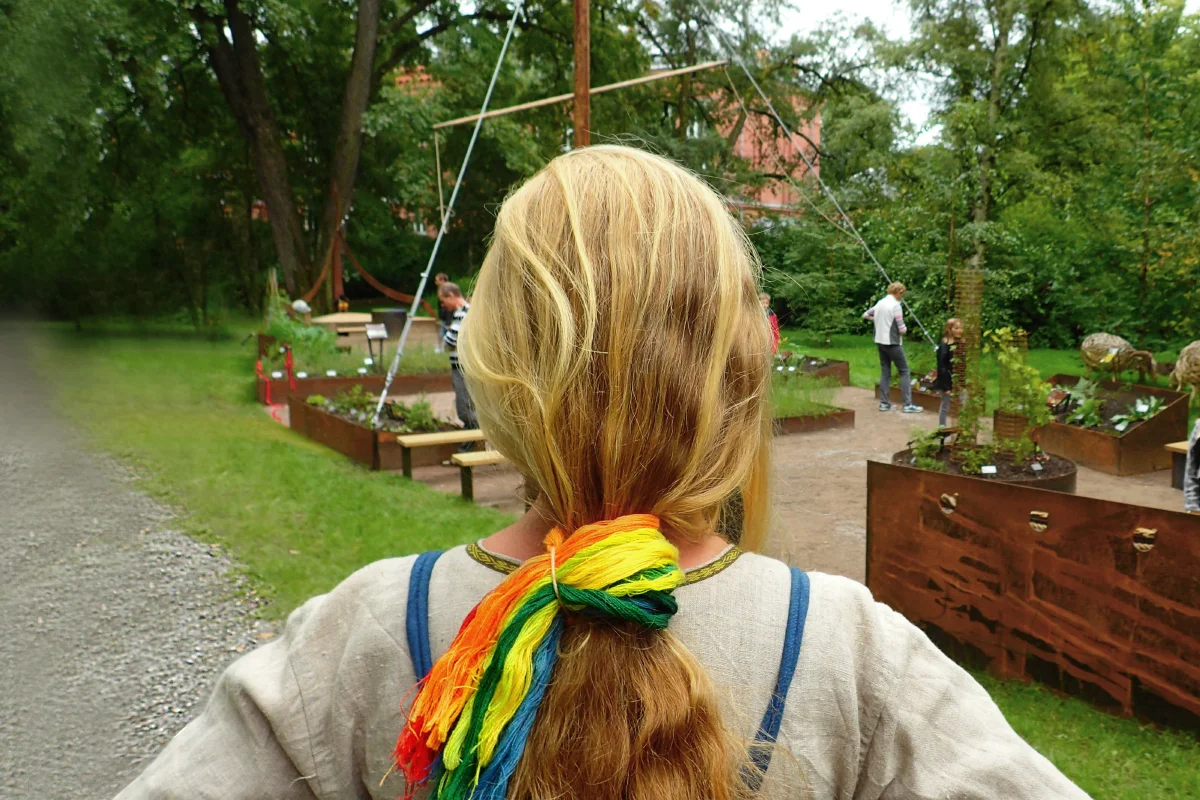 Woman from behind in a viking costume in a viking garden 